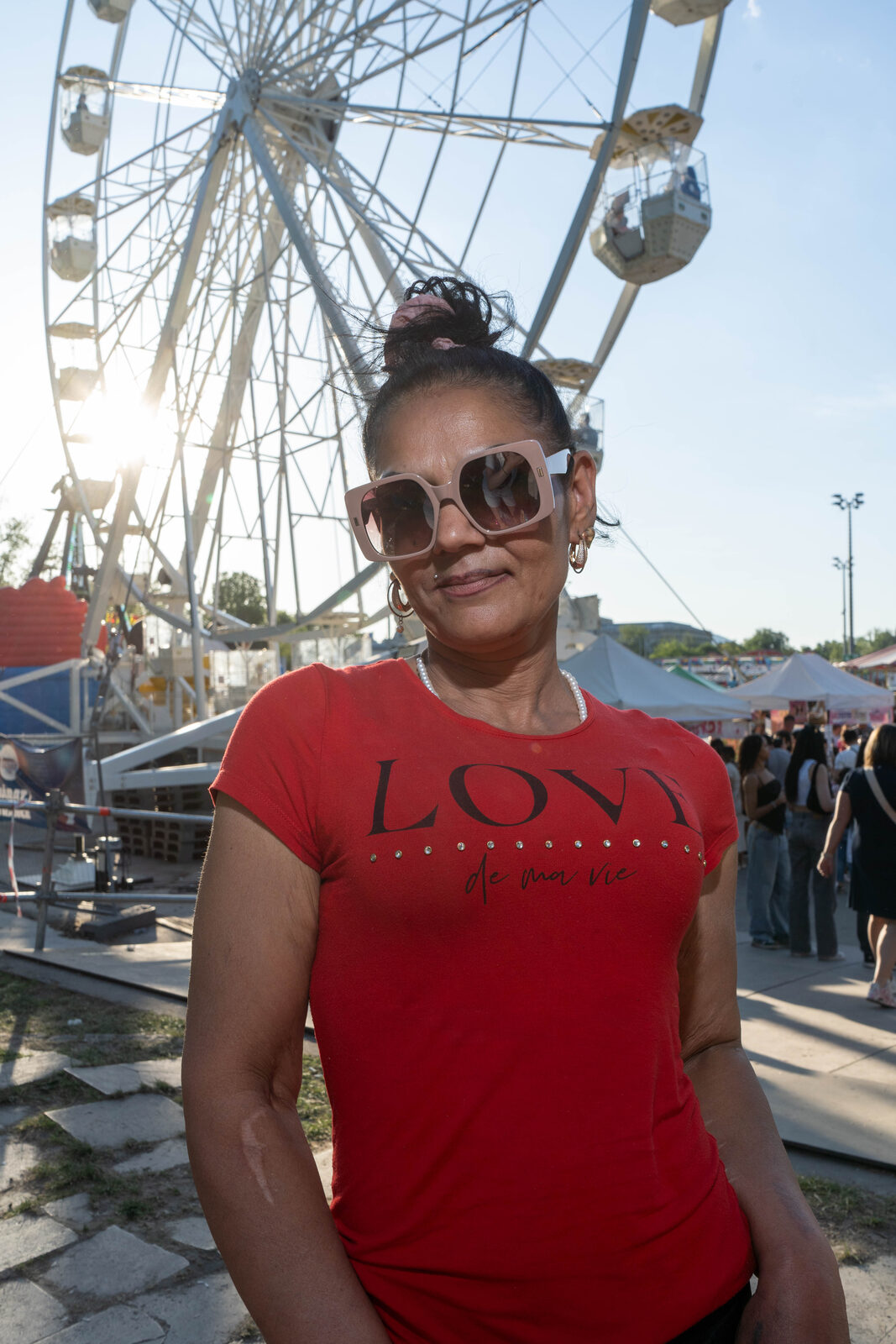 Woman in a red LOVE t-shirt in front of a ferris wheel